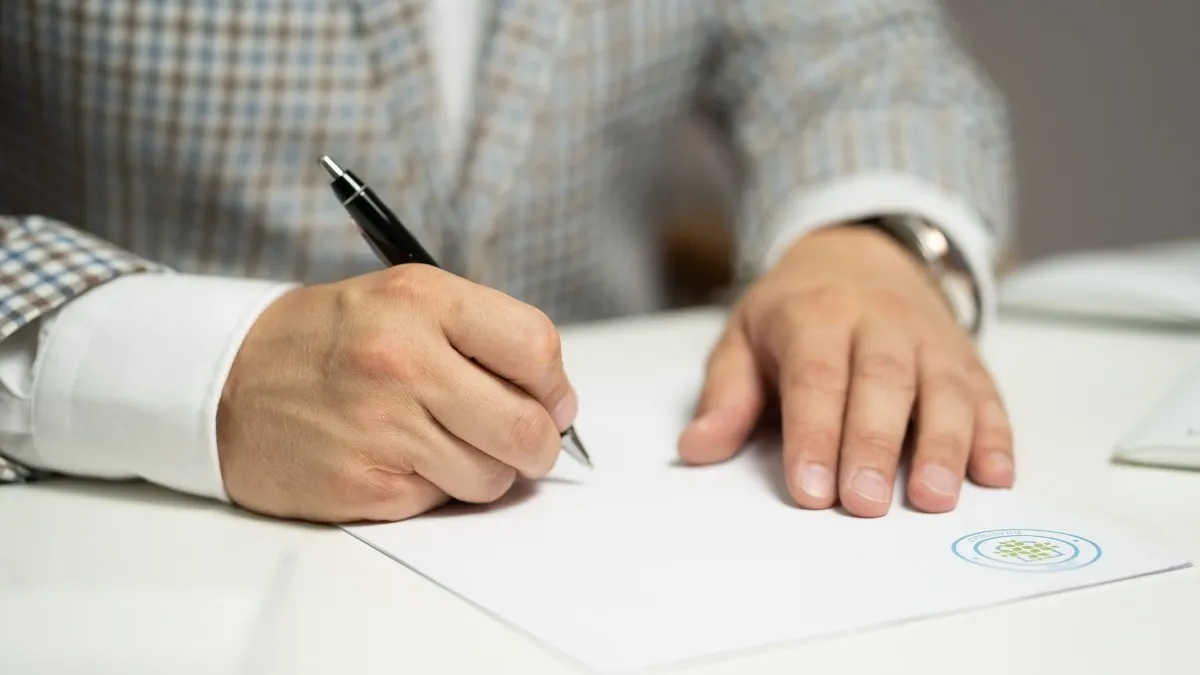 homem escrevendo em um papel, tipos de avaliação escolar