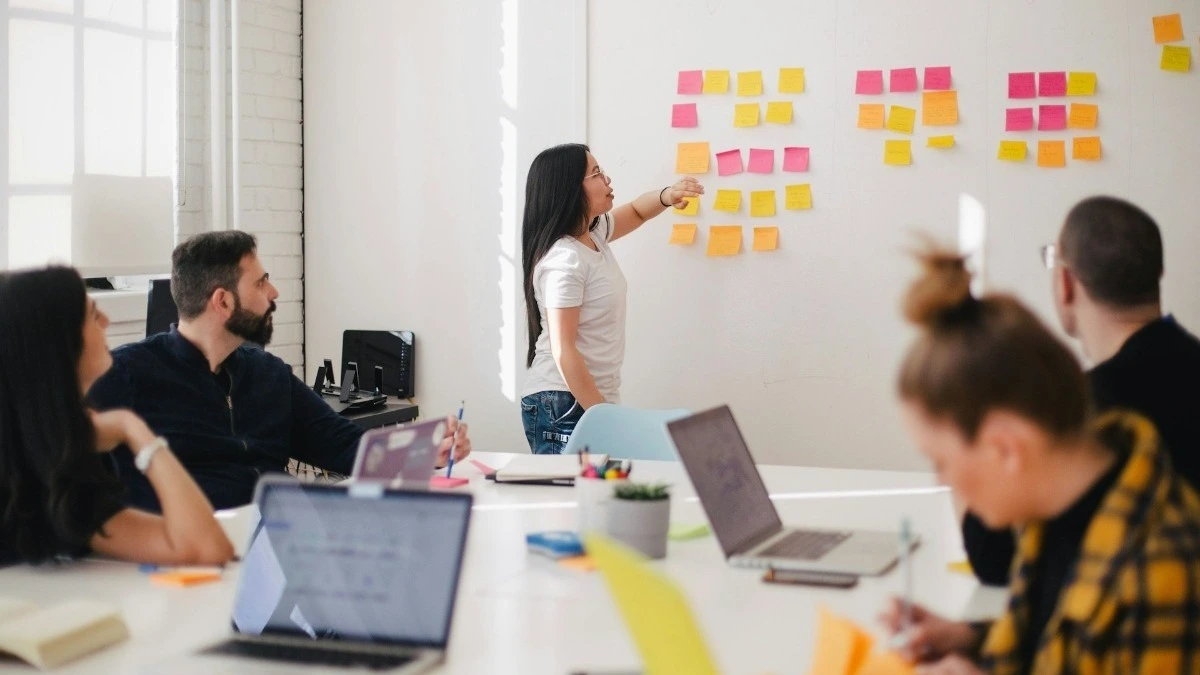 pessoas conversando em uma sala em ambiente corporativo, capacitação profissional