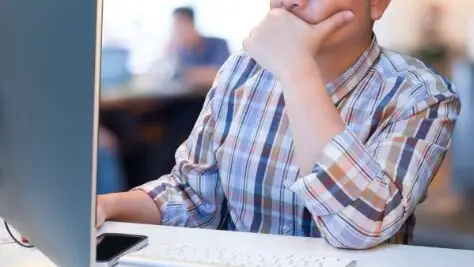 pessoa mexendo no computador em ambiente corporativo, ia na criação de avaliações