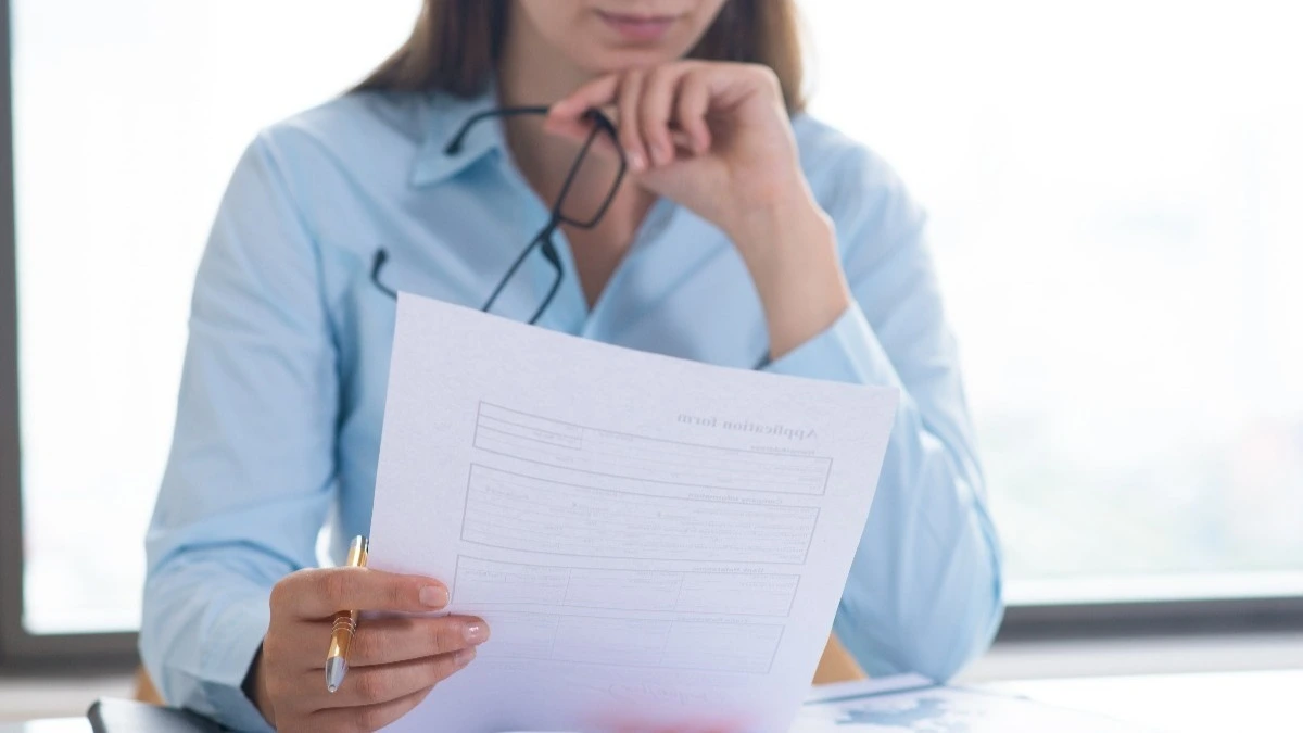 mulher lendo um teste em uma folha em ambiente corporativo, teste psicológico