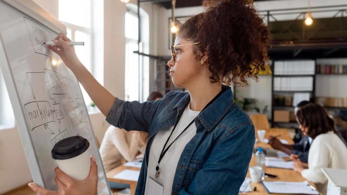 mulher em um ambiente corporativo escrevendo em um quadro, plano de carreira