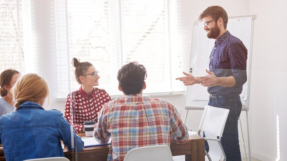 pessoas conversando em ambiente corporativo, treinamento de liderança