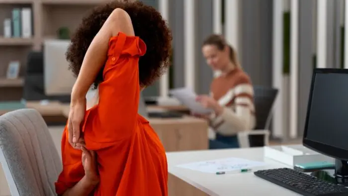 pessoa se alongando em ambiente corporativo, ergonomia no trabalho
