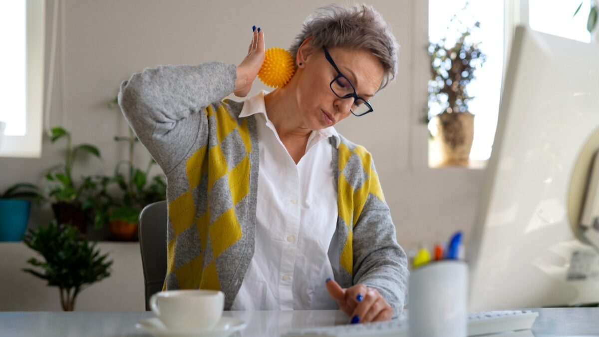 mulher usando bola para alongamento no ambiente de trabalho, doença ocupacional