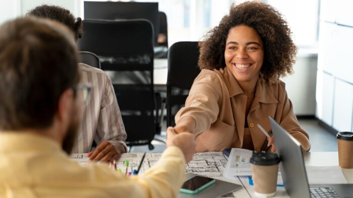 mulher sorridente em ambiente corporativo, job rotation