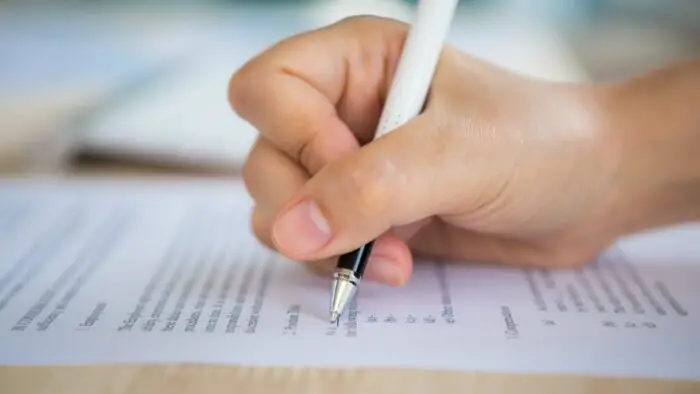 pessoa escrevendo, prova objetiva ou discursiva