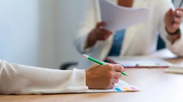 pessoa escrevendo em um papel, empresa organizadora de concurso público