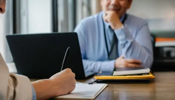 pessoa mexendo em notebook em ambiente corporativo, competências e habilidades nas avaliações