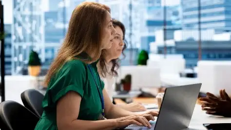 mulheres conversando em ambiente corporativo com notebook, processo seletivo online