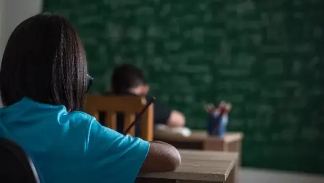 Garoto escreve um livro na sala de aula, captação e retenção de alunos